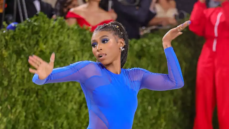 Gymnast Nia Dennis at the Met Gala with a marching band