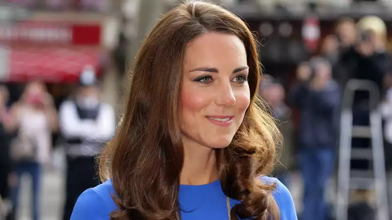 Kate Middleton in a bright blue dress reminiscent of Meghan Markle