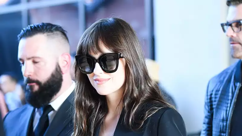 Dakota Johnson wears Gucci lingerie under a suit in Milan.