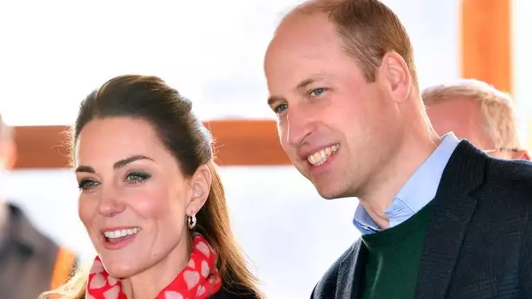 Kate Middleton smiles with Prince William in a heart-patterned scarf.