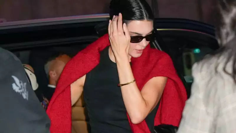 Kendall Jenner elevates her all-black look with a bright red sweater