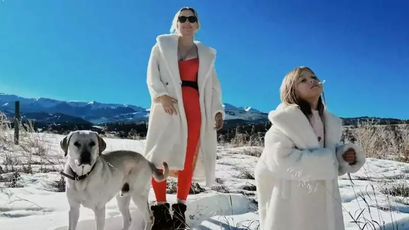 Kate Hudson's daughter Lani wears a Max Mara coat and her mom's matching winter white coat in Aspen.